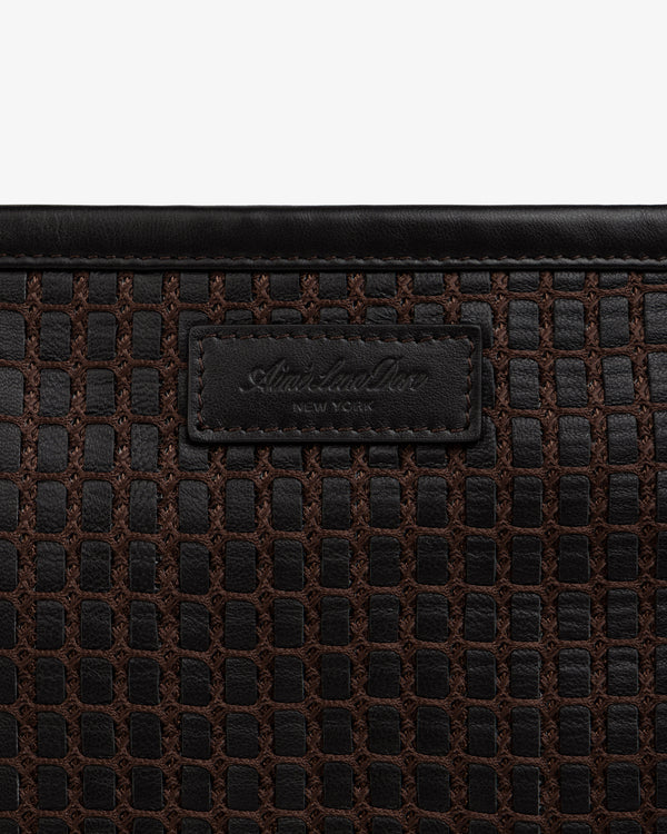 Close-up of a brown Woven Leather Tote Bag with a branded leather label.