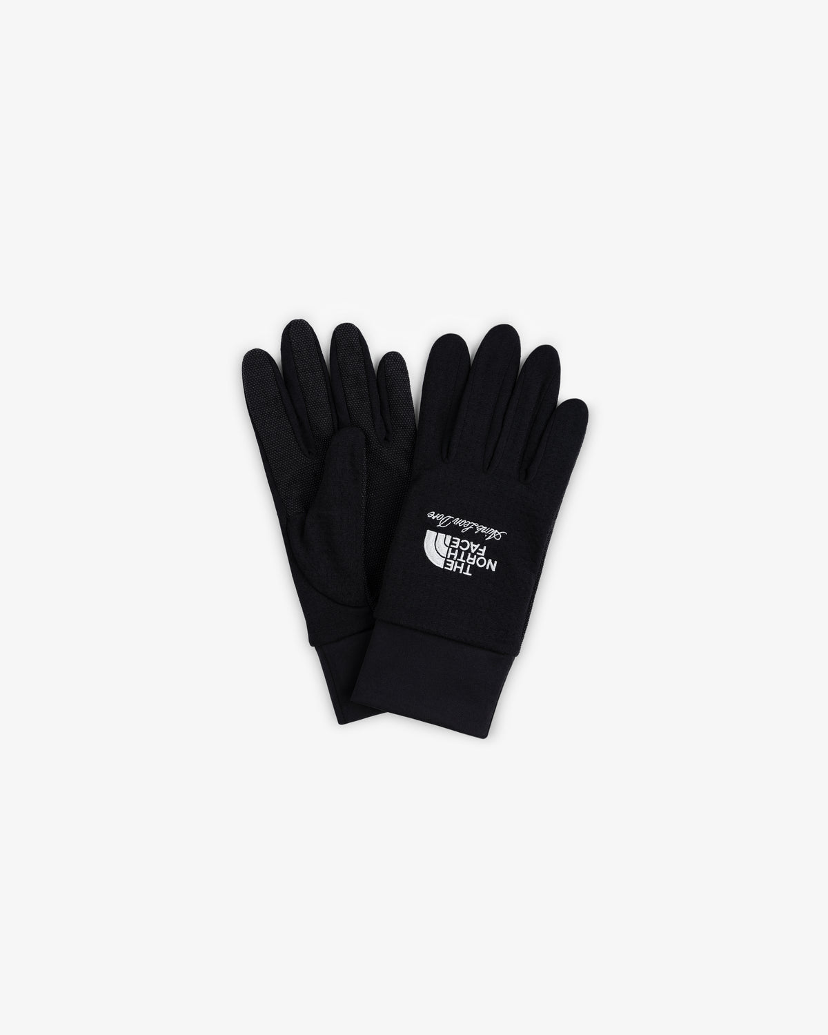 ALD/The North Face DOTKNIT™ Liner Gloves in black with white logo, laid flat on a white background.