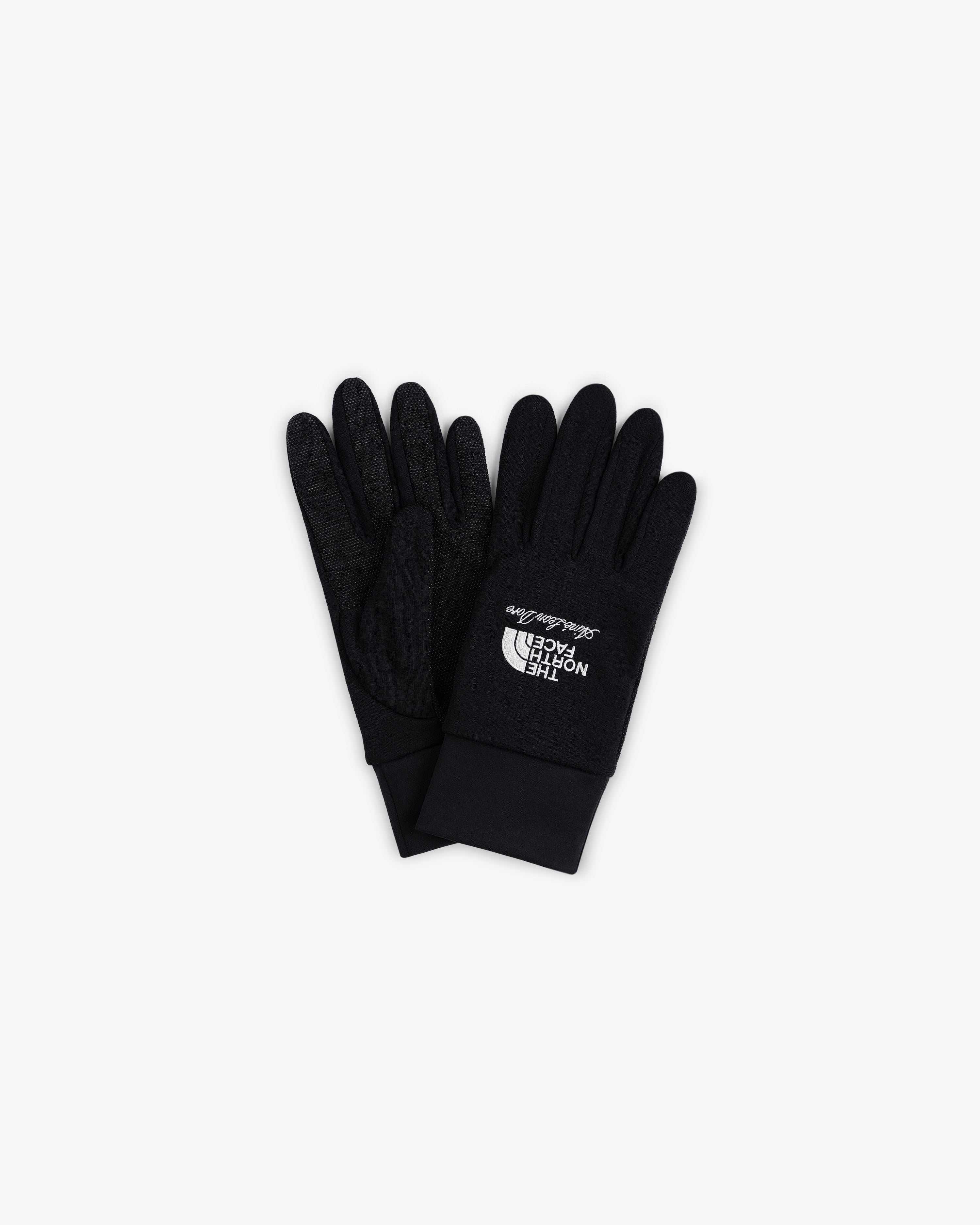 ALD/The North Face DOTKNIT™ Liner Gloves in black with white logo, laid flat on a white background.