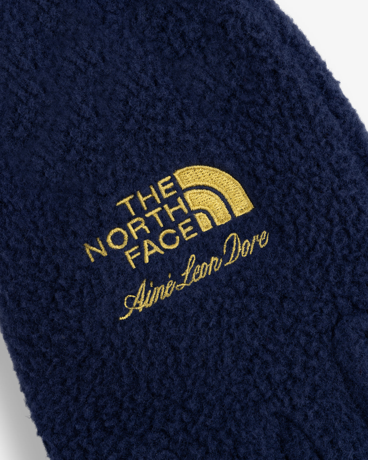 Navy ALD / The North Face Fleece Gloves with gold embroidered logos shown in close-up.