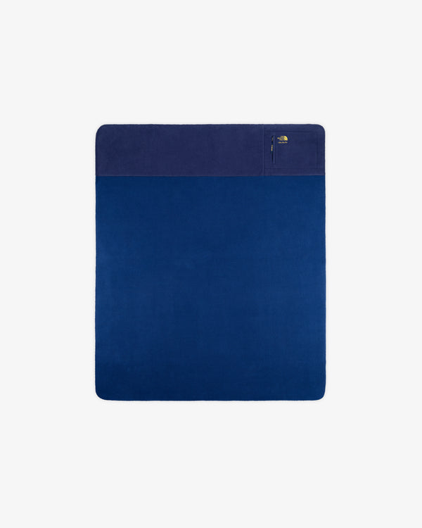 ALD/The North Face dark blue packable fleece blanket with a pale blue edge and a zippered corner pocket.