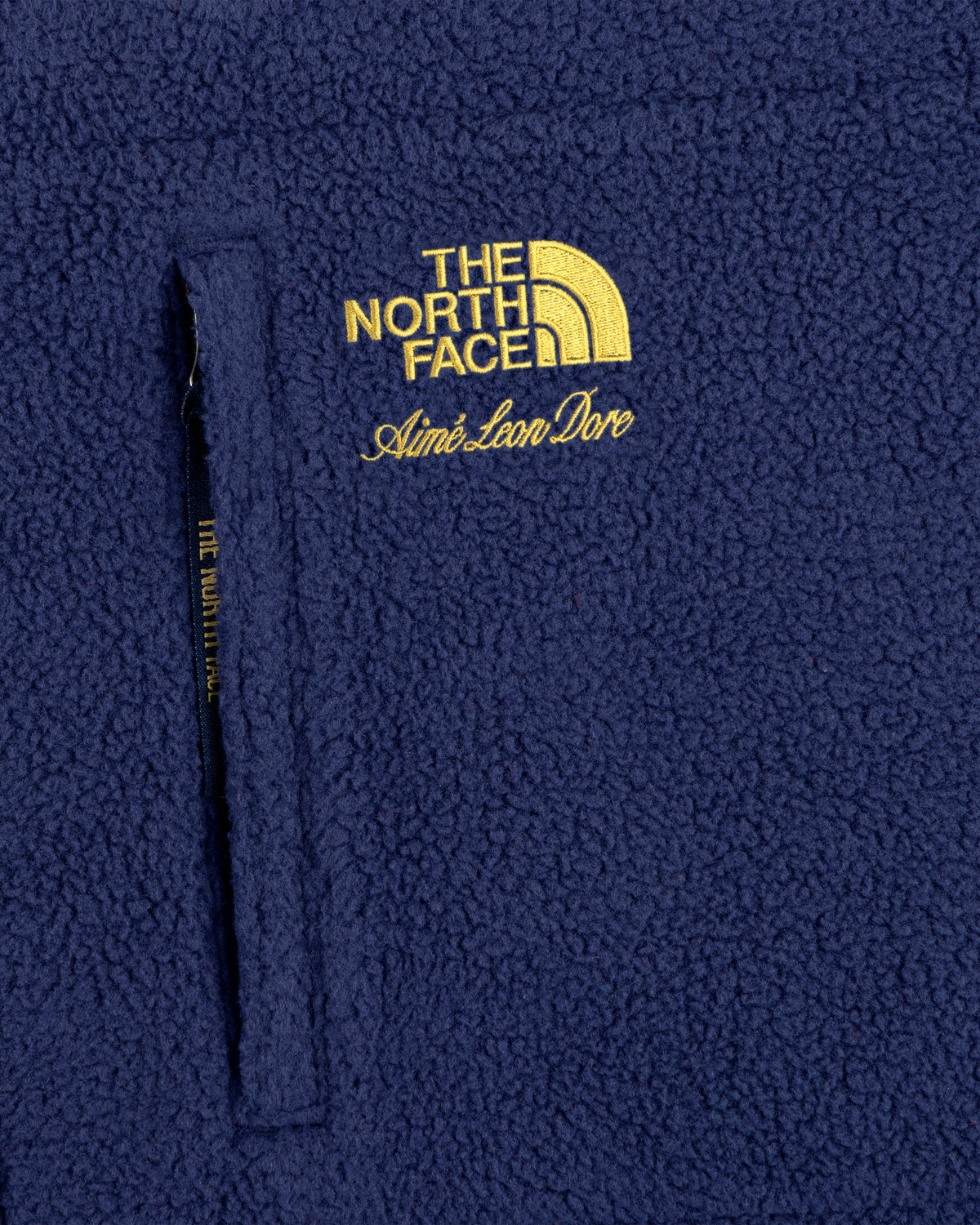 Close-up of the ALD / The North Face Packable Fleece Blanket with co-branded yellow embroidered logos.