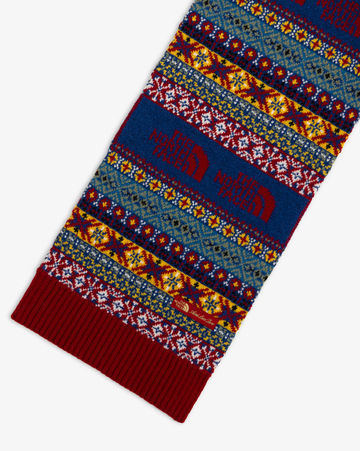 ALD / The North Face Fair Isle Scarf featuring a multicolored pattern, large red brand logos, and a ribbed edge.