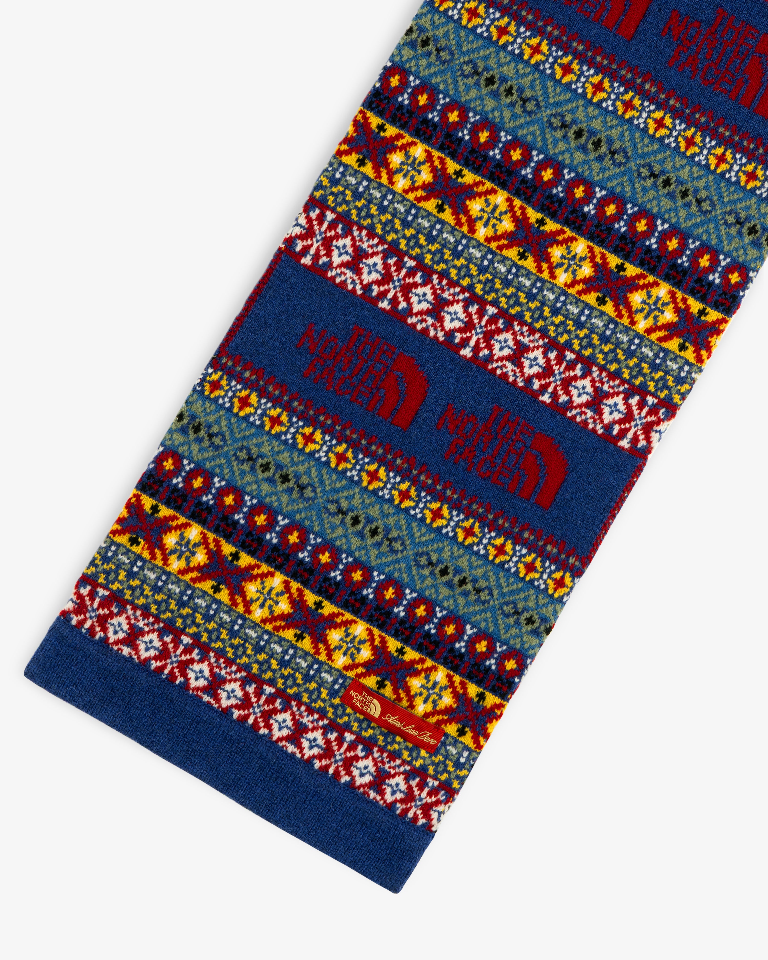 The ALD / The North Face Fair Isle Scarf features a blue, red, and yellow knit pattern with woven logos.