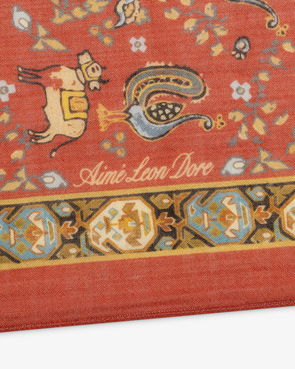 Red patterned Archival Print Wool Silk Bandana with animals, flowers, and Aimé Leon Dore script near the edge.