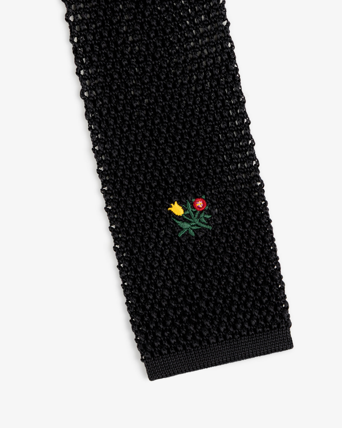 Crest Silk Knit Tie in black, featuring a small embroidered flower bouquet.