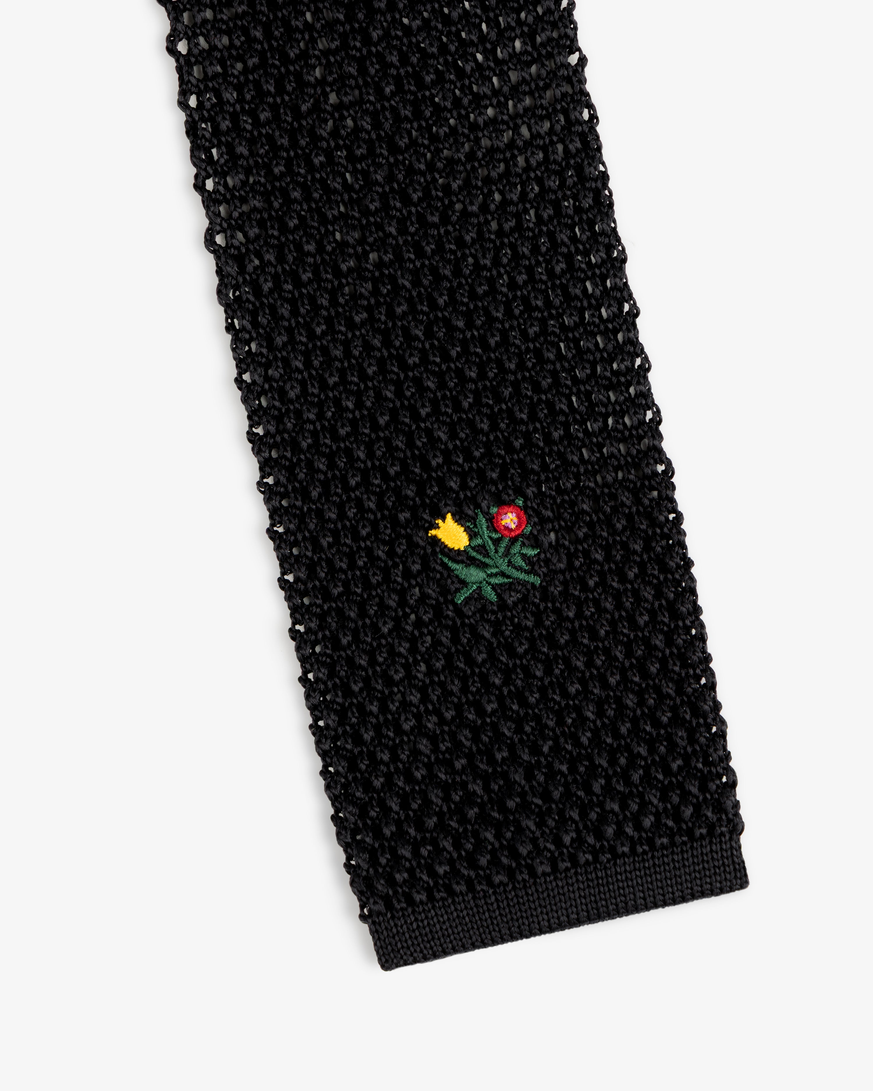 Crest Silk Knit Tie in black, featuring a small embroidered flower bouquet.