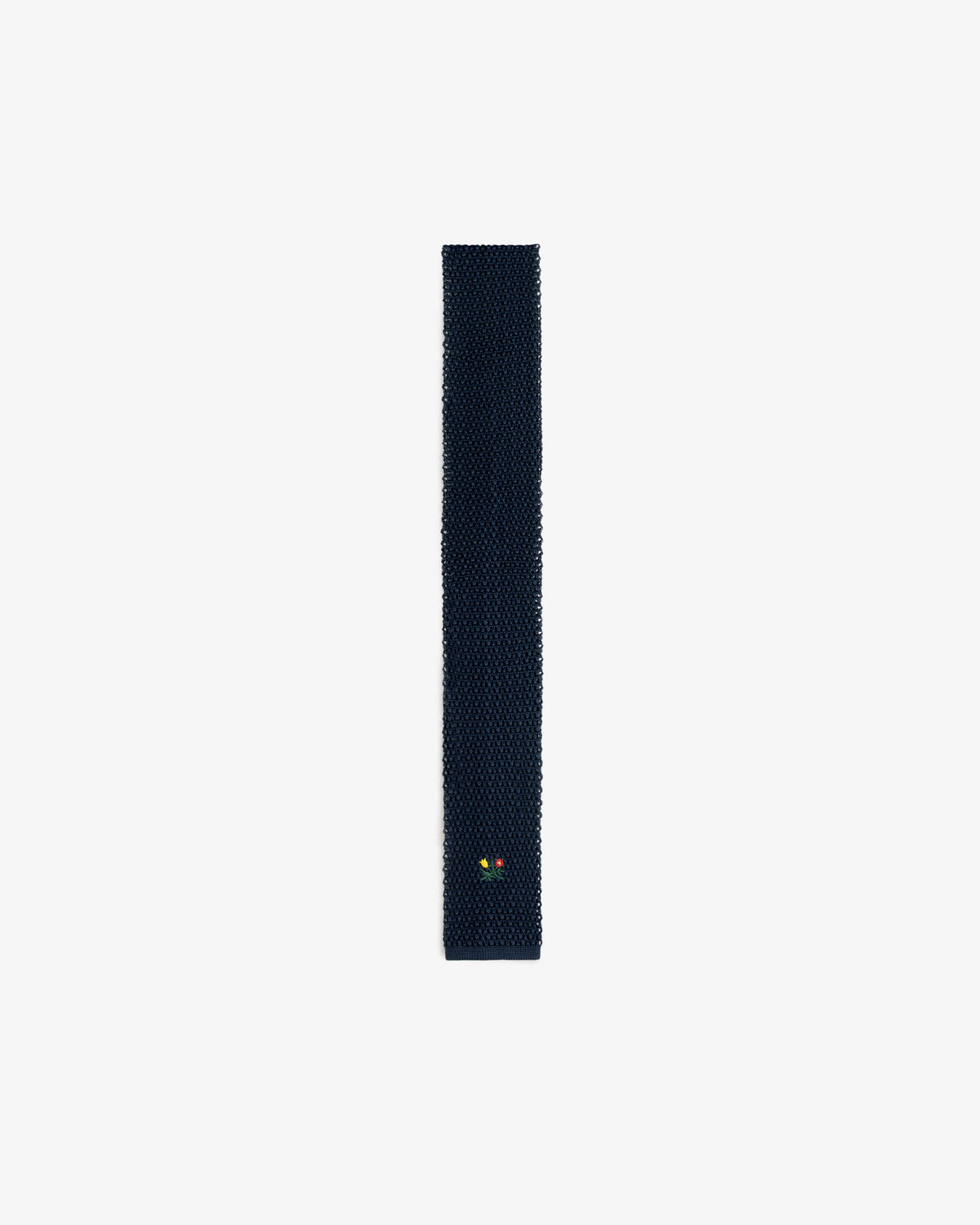 Dark navy Crest Silk Knit Tie with a small floral embroidery near the pointed tip.