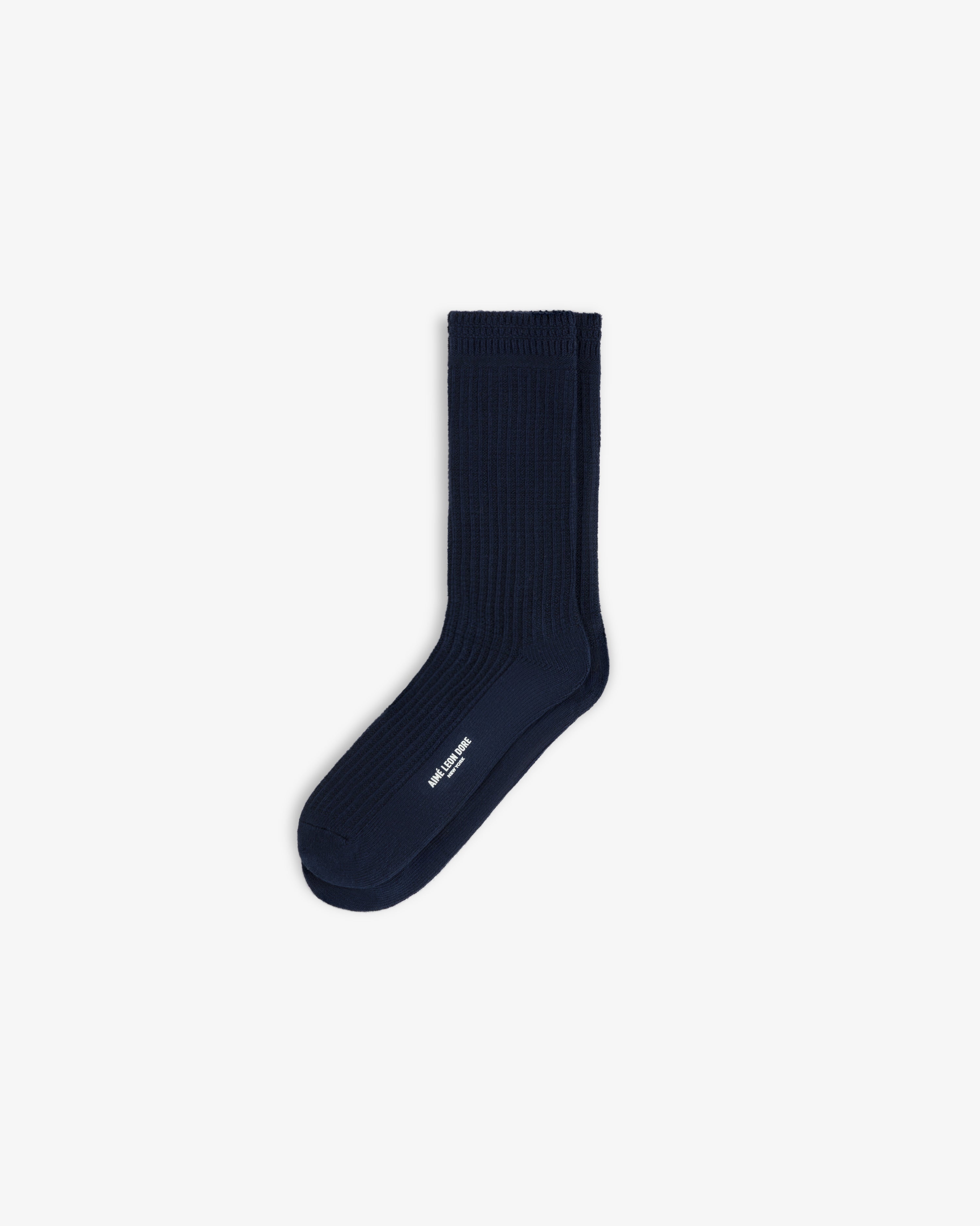 A pair of navy blue Cotton Waffle Sock crew socks with white branding on the side.
