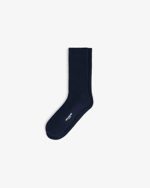 A pair of navy blue Cotton Waffle Sock crew socks with white branding on the side.