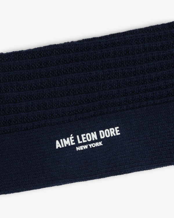 Dark navy blue ribbed cuff of a Cotton Waffle Sock with Aimé Leon Dore New York printed in white.