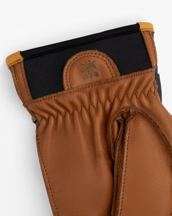 Wakayama Gloves in tan leather with a black neoprene cuff and an embossed logo patch on the wrist.