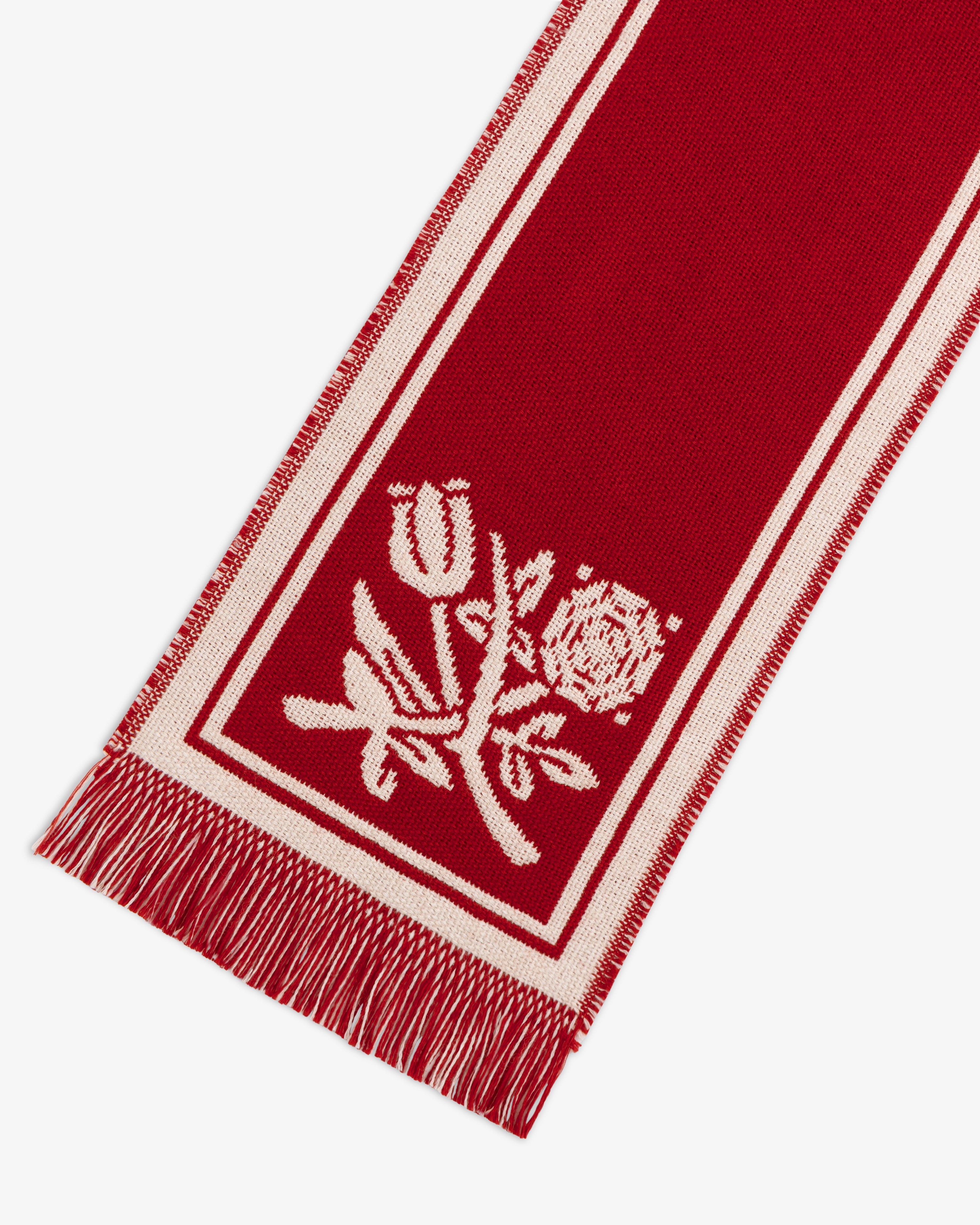 Wool Script Scarf in red with a white border, floral pattern, and fringed edges.