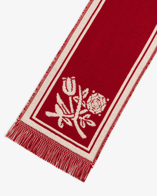 Wool Script Scarf in red with a white border, floral pattern, and fringed edges.