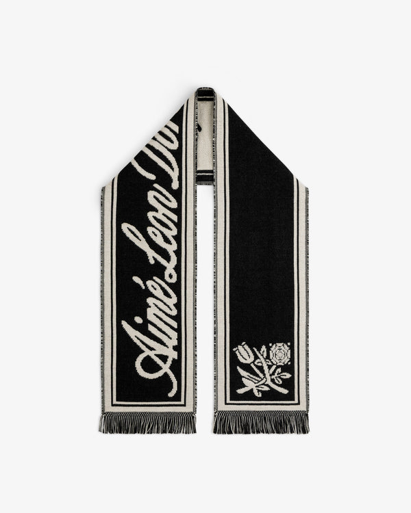 Wool Script Scarf in black and cream knit with cursive text and a floral graphic on the ends.