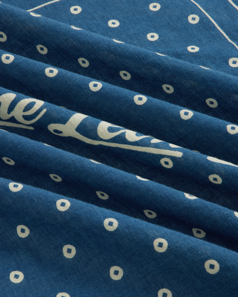Indigo Dyed Cotton Bandana in blue with a white dot pattern and partial script text.