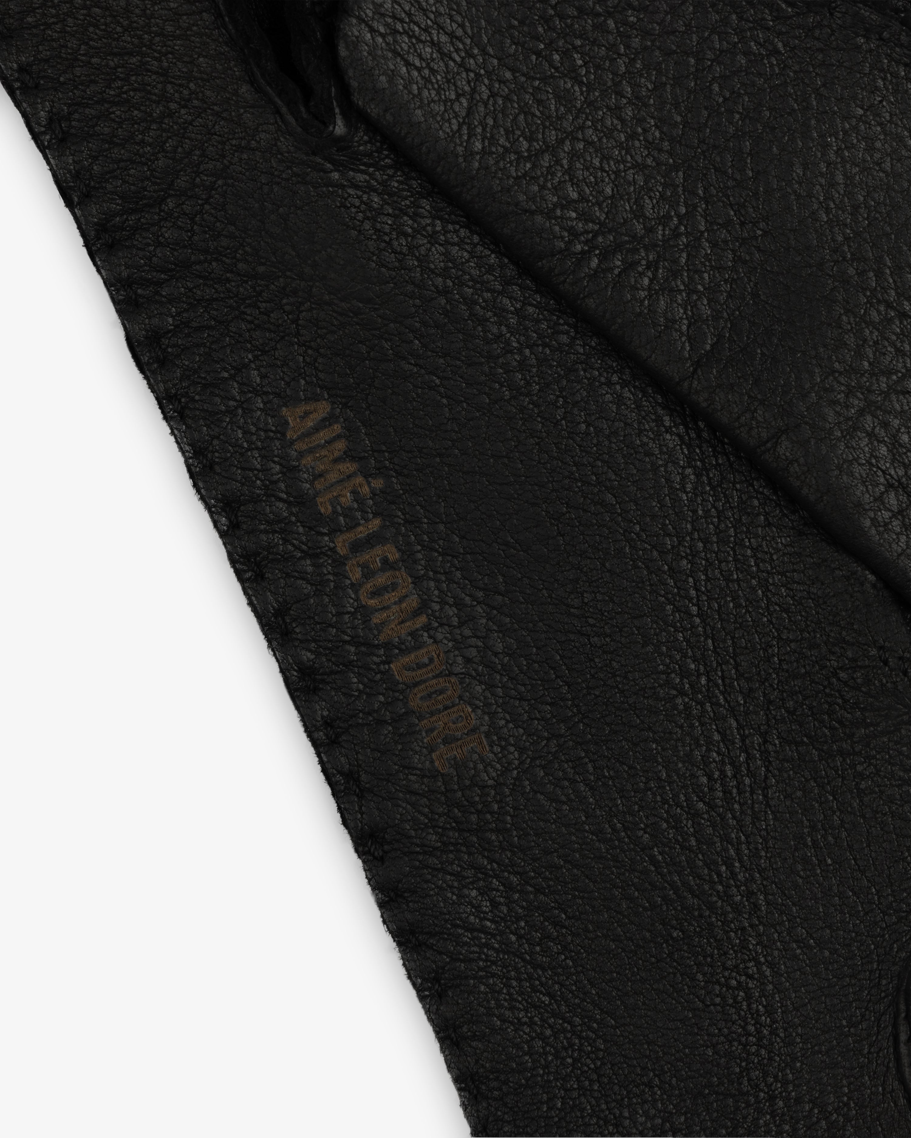 Black Henry Gloves in leather featuring the embossed text Aime Leon Dore.