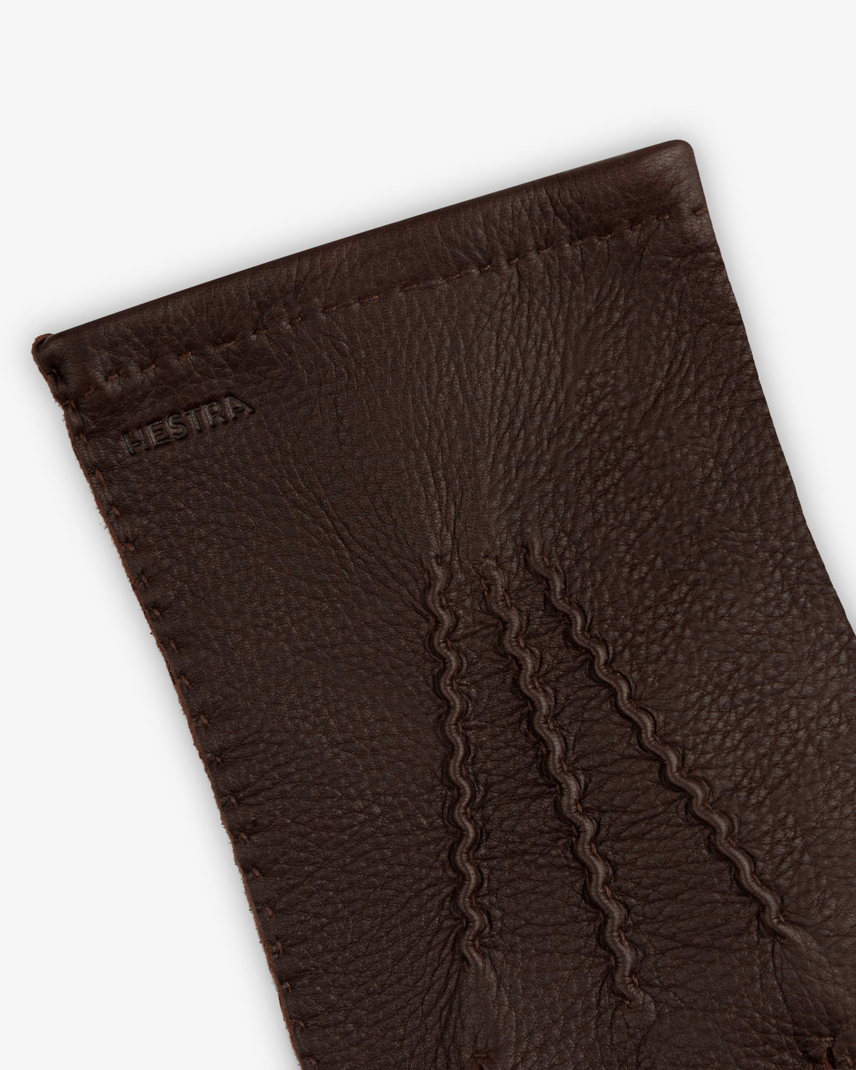 Close-up of brown leather Henry Gloves with three decorative stitched lines on the back.