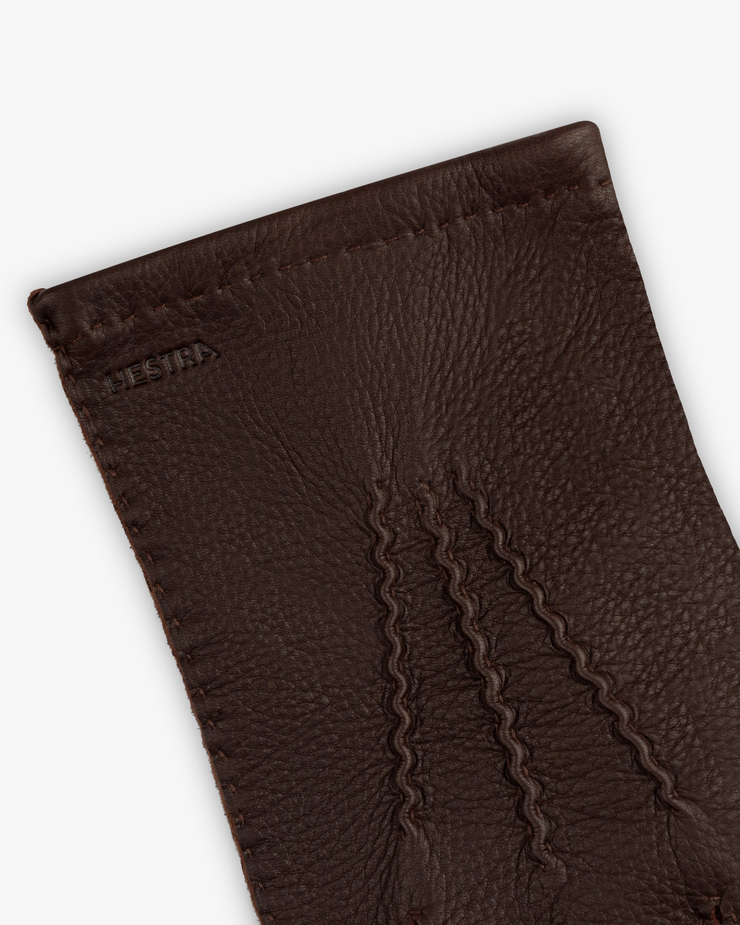 Close-up of brown leather Henry Gloves with three decorative stitched lines on the back.