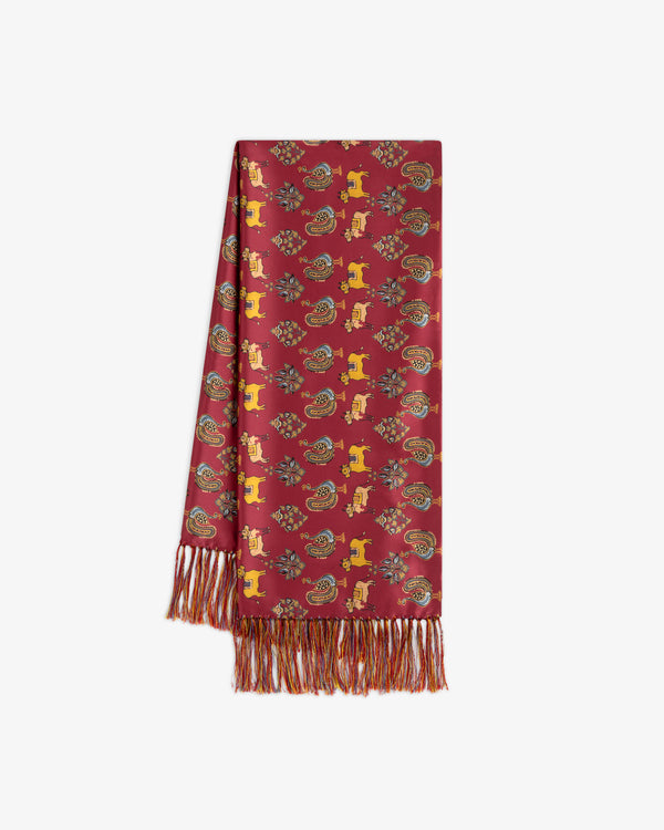 Archival Print Silk Fringe Scarf in red silk with a repeating pattern of stylized animals, paisley motifs, and fringed ends.