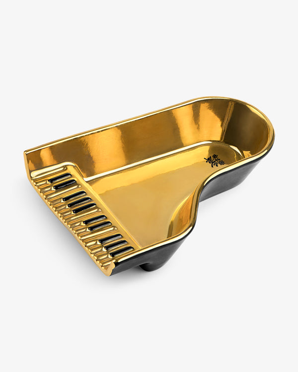 Gold and black Piano Ashtray shaped like a grand piano with detailed keyboard on one side.