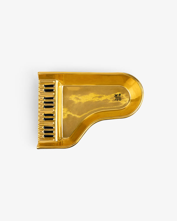 Piano Ashtray shaped like a golden grand piano with black and white keys, viewed from above on white background.