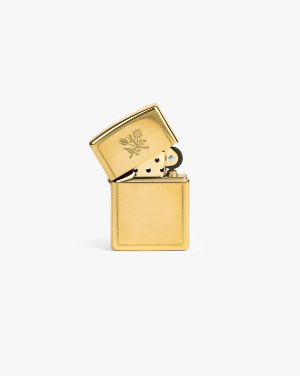 Graphic Zippo Lighter with floral engraving on the lid, open and upright on a plain white background.