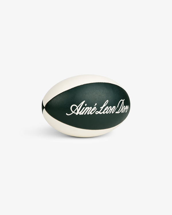 The Script Rugby Ball is dark green and white, featuring Aimé Leon Dore written in cursive on its side.