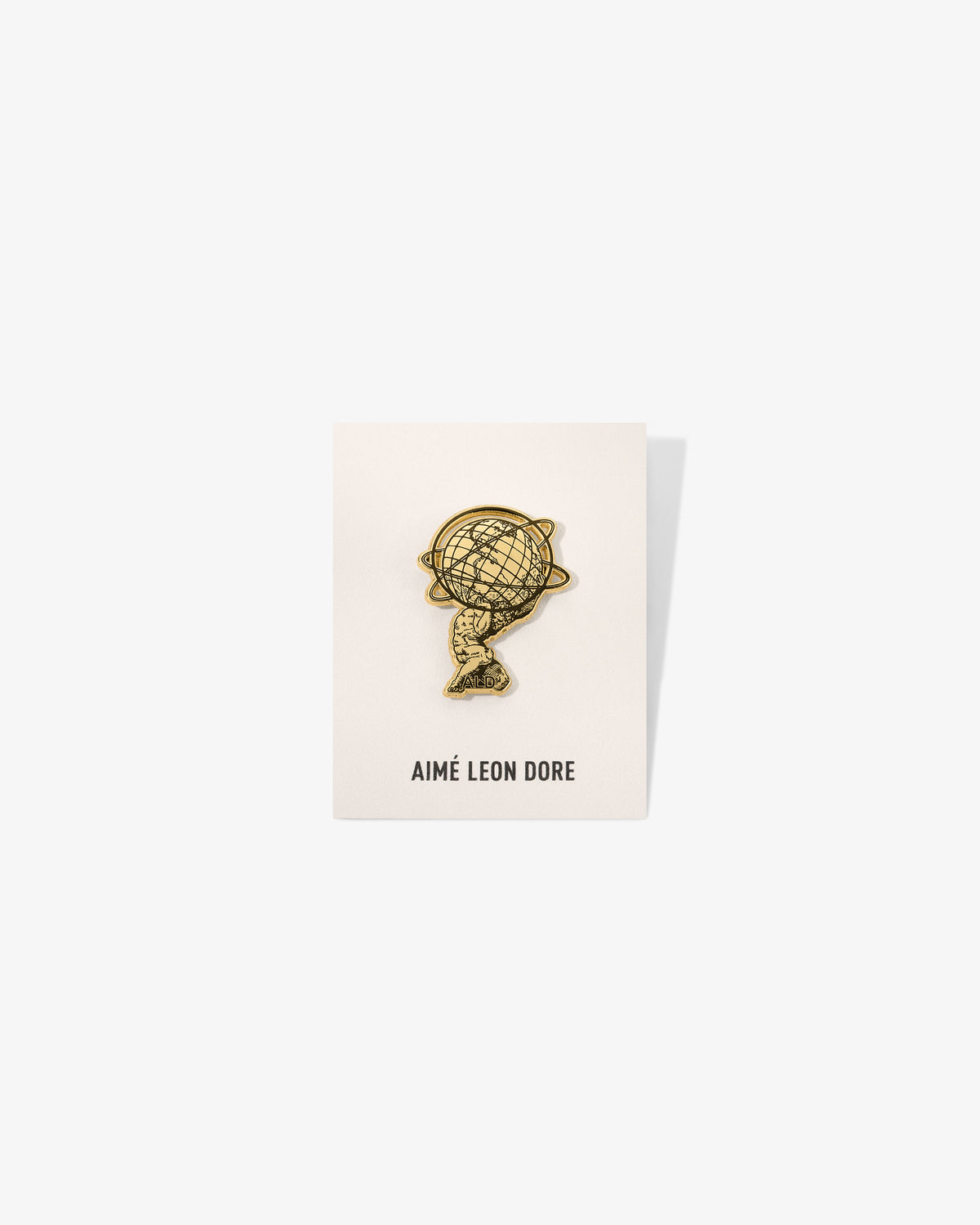 A Graphic Pin is displayed on a white card with AIMÉ LEON DORE printed at the bottom.
