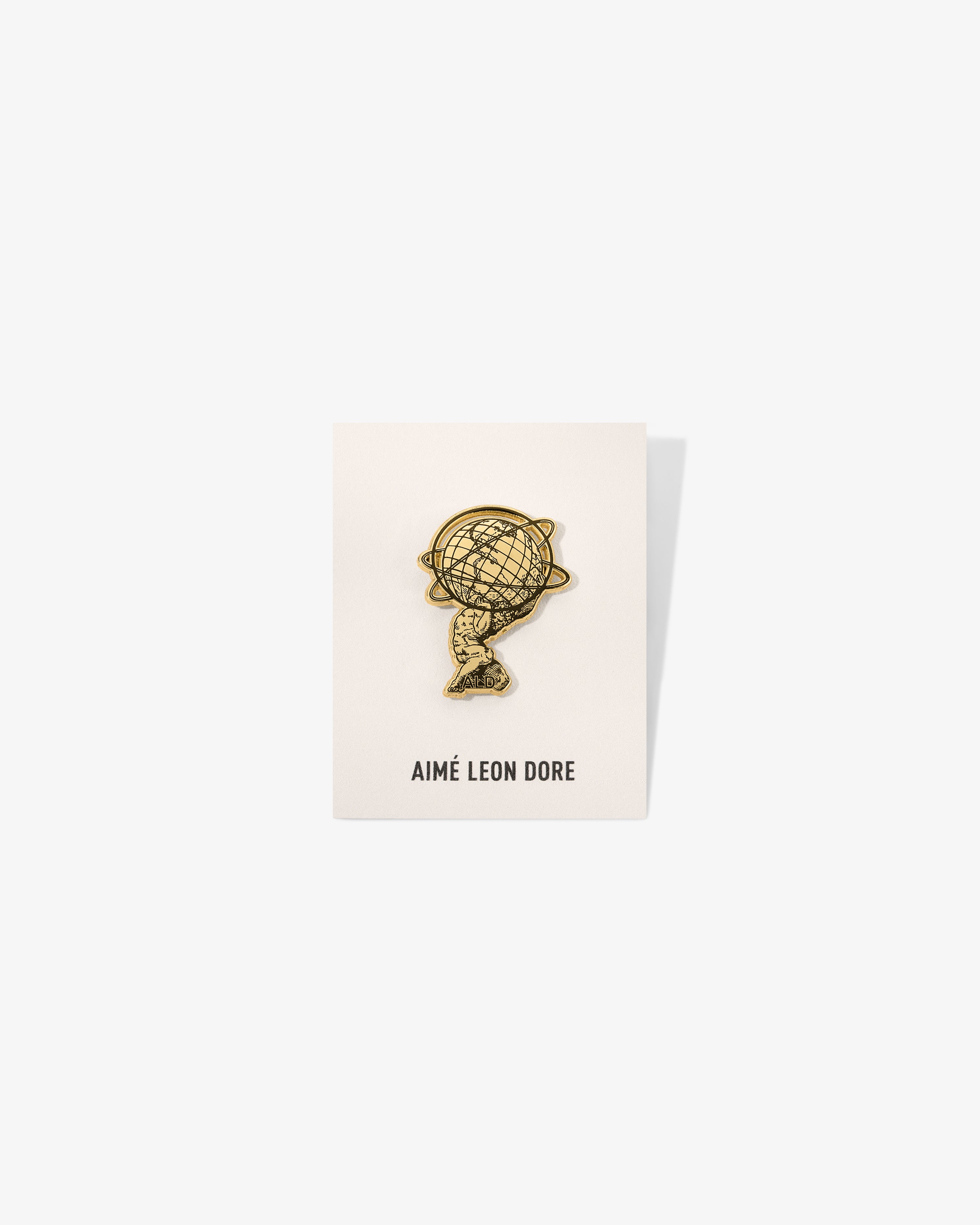 A Graphic Pin is displayed on a white card with AIMÉ LEON DORE printed at the bottom.