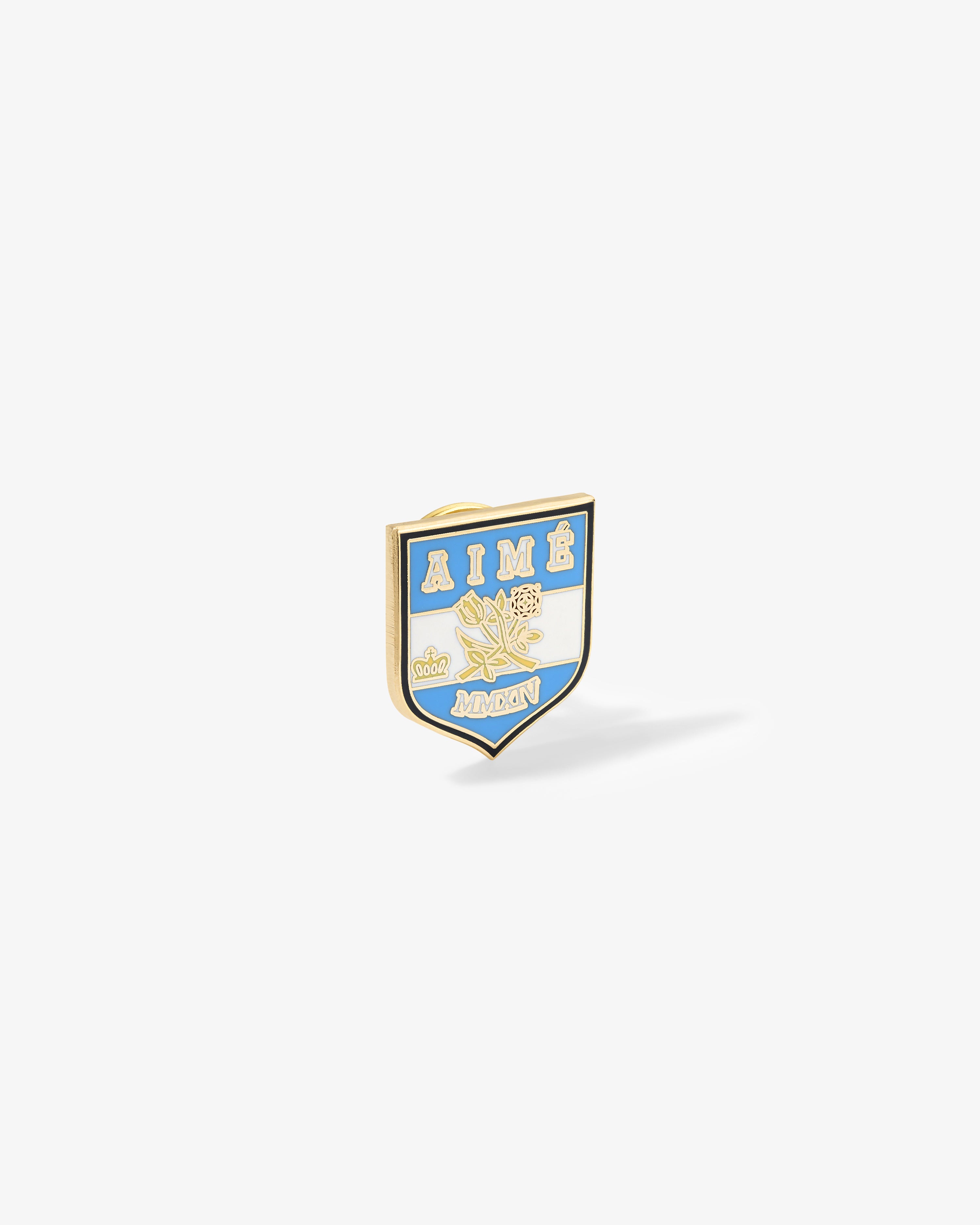 Shield-shaped Graphic Pin with AIMÉ & AMON, roses, blue, white & gold details on a white background.