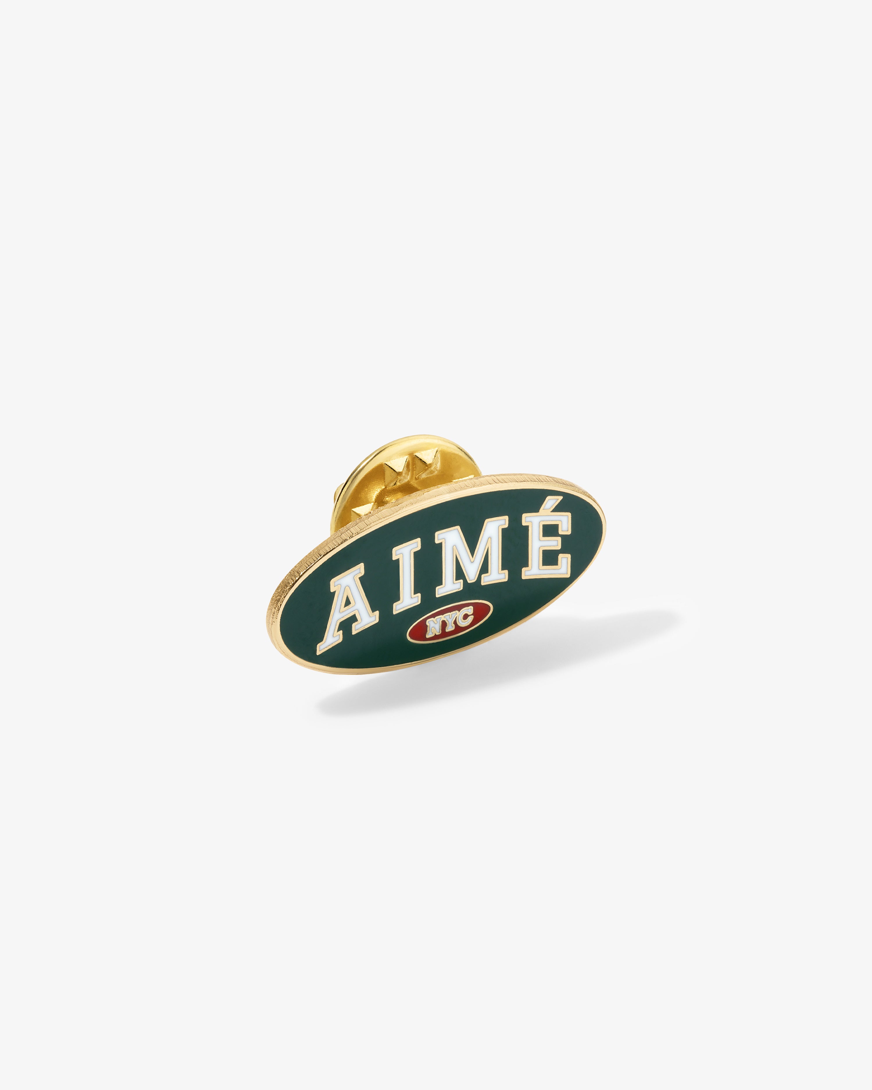 Graphic Pin featuring AIMÉ in white on green, small red NYC logo, and visible gold backing.