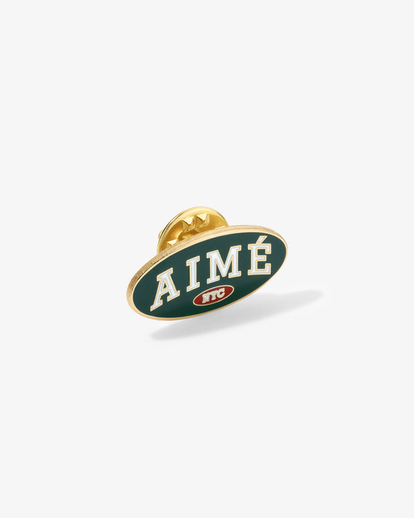 Graphic Pin featuring AIMÉ in white on green, small red NYC logo, and visible gold backing.