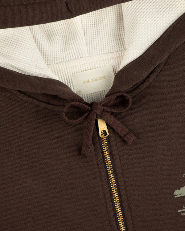 Close-up of the Unisphere Waffle Lined Full-Zip Hoodie with gold zipper, white lining, and collar tag visible.