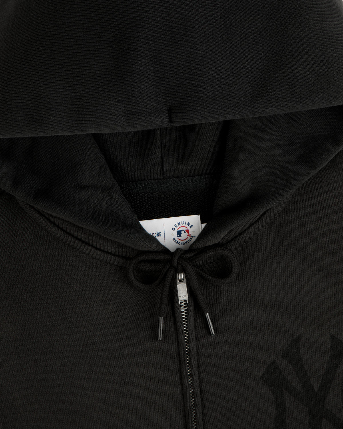 Close-up of a Yankees Washed Full-Zip Hoodie in black, featuring a drawstring and a visible inside collar tag.