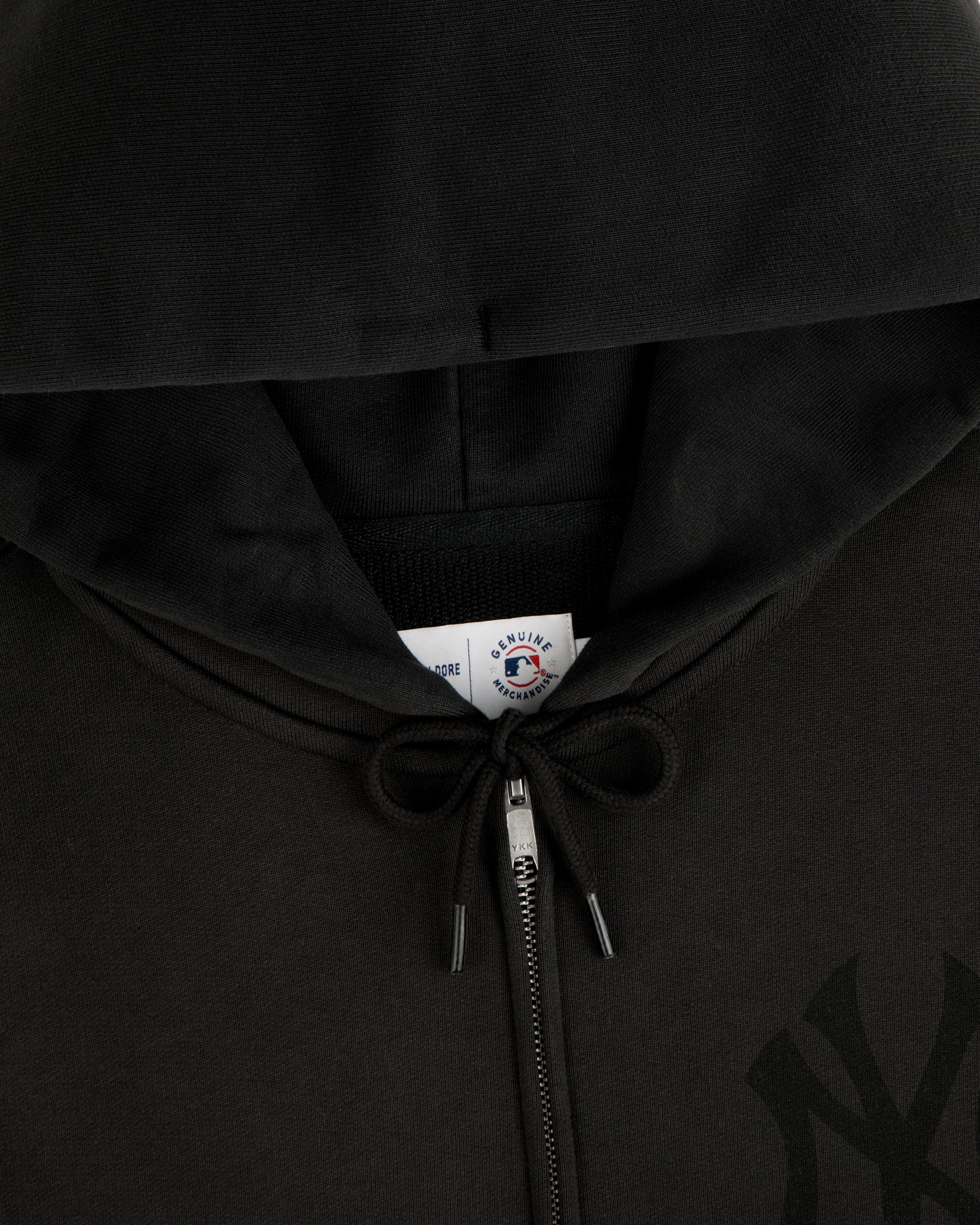 Close-up of a Yankees Washed Full-Zip Hoodie in black, featuring a drawstring and a visible inside collar tag.