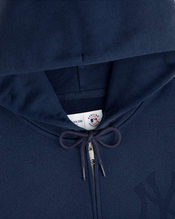 Close-up of a Yankees Washed Full-Zip Hoodie in navy blue, featuring drawstrings and a visible label inside the hood.