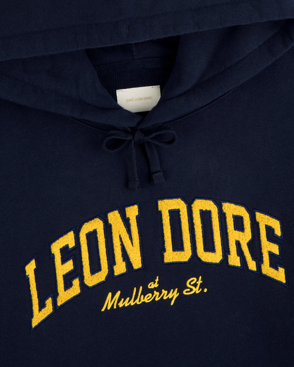 Mulberry Letterman Hoodie: Navy with yellow LEON DORE and “at Mulberry St.” in cursive underneath.