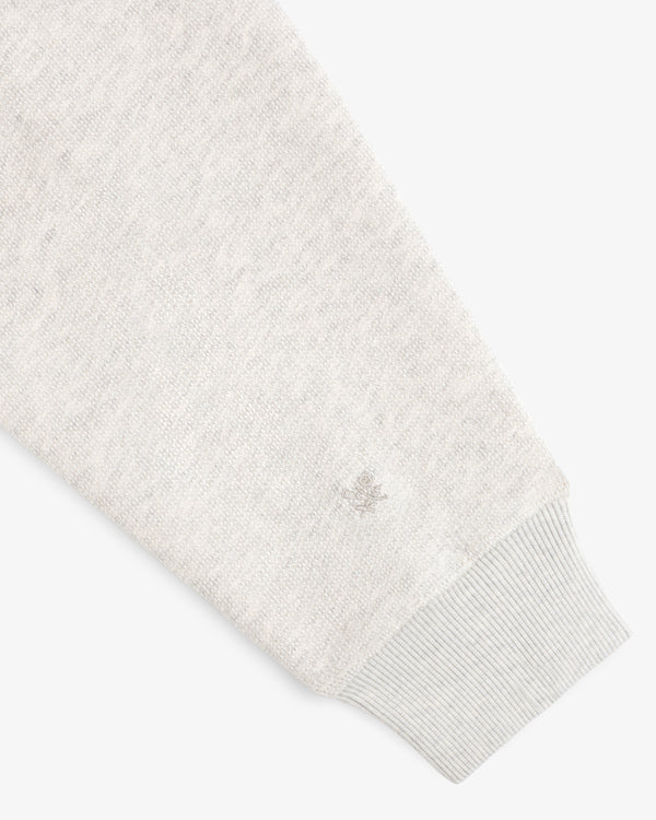 Stone Washed Marina Hoodie sleeve with ribbed cuff and small embroidered emblem shown on a white background.
