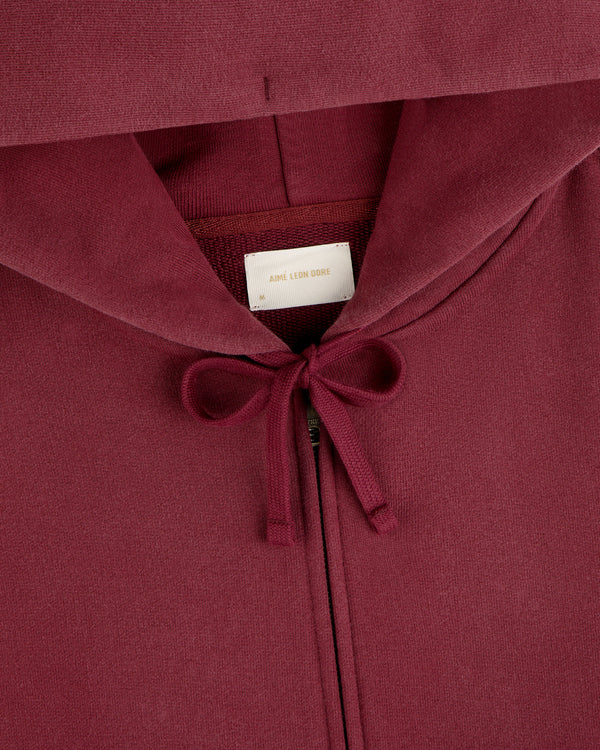 Washed Full Zip Hoodie in maroon with a drawstring hood and a brand label at the neck.