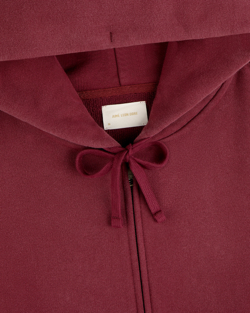 Washed Full Zip Hoodie in maroon with a drawstring hood and a brand label at the neck.