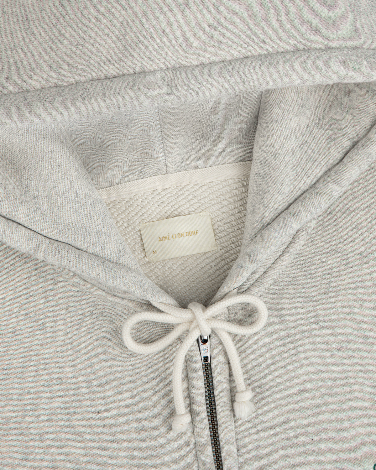 Light gray Script Full Zip Hoodie with a drawstring hood and a brand label at the neckline.