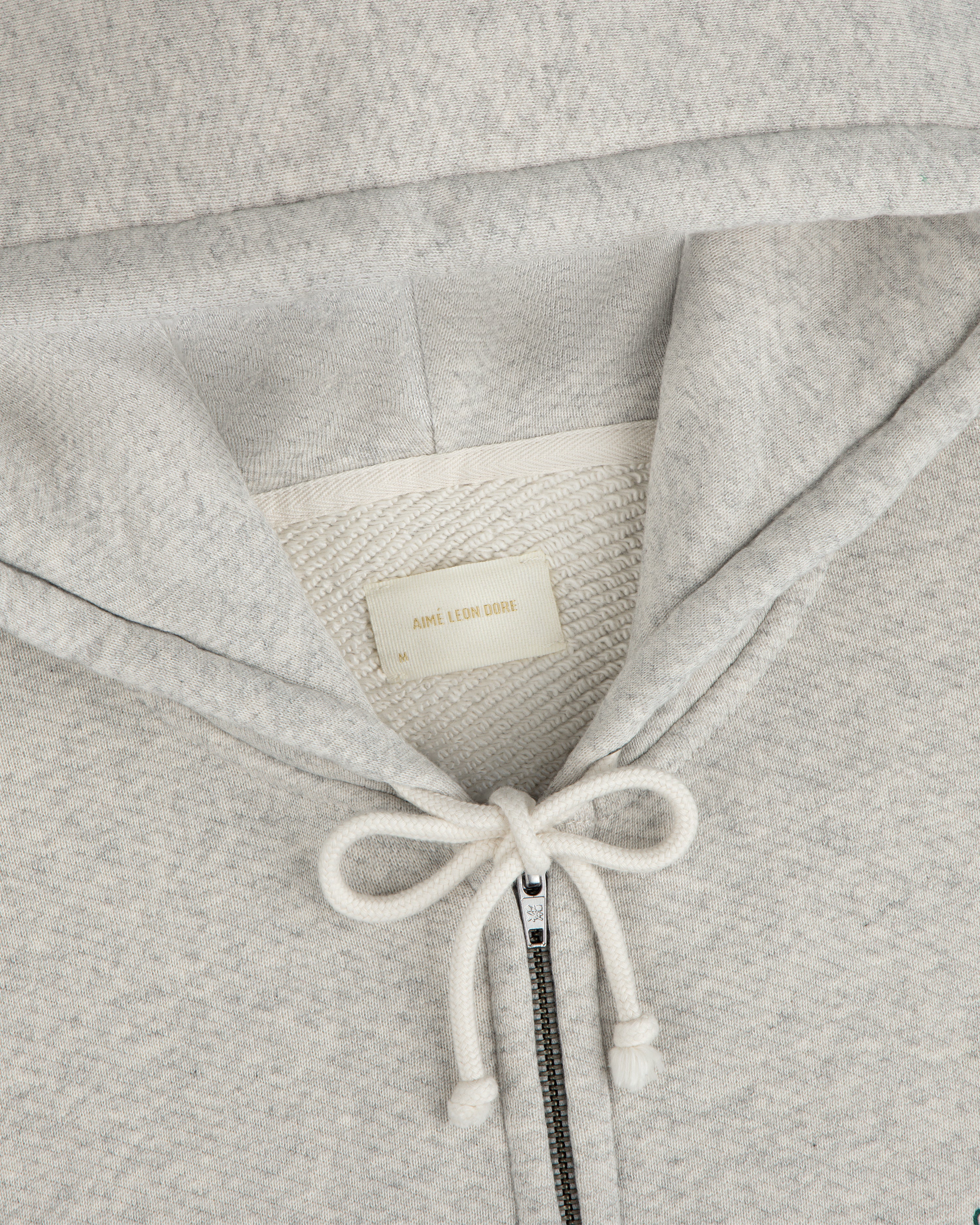 Light gray Script Full Zip Hoodie with a drawstring hood and a brand label at the neckline.