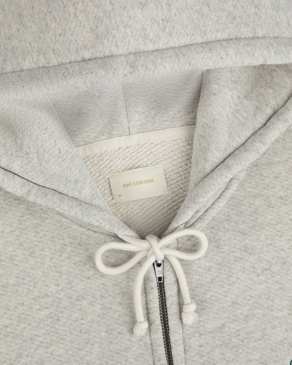 Light gray Script Full Zip Hoodie with a drawstring hood and a brand label at the neckline.