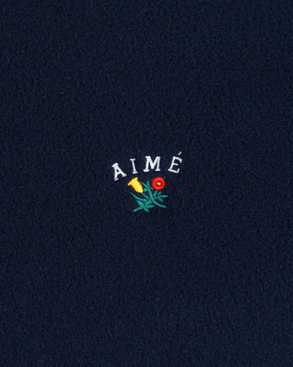 Navy Crest Fleece Full-Zip Hoodie with AIMÉ text and a small yellow-red embroidered flower with green leaves.