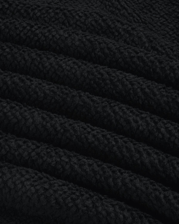 Close-up of black textured fleece fabric with diagonal folds on a Fleece Performance Hoodie.