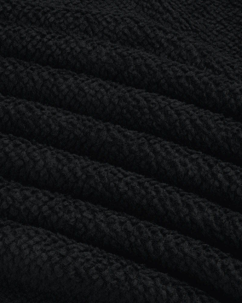 Close-up of black textured fleece fabric with diagonal folds on a Fleece Performance Hoodie.