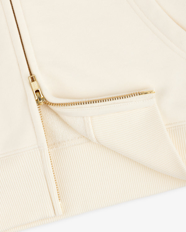 Close-up of the cream-colored ALD / Olympiacos F.C. Full Zip Hoodie, featuring a gold-toned metal zipper.
