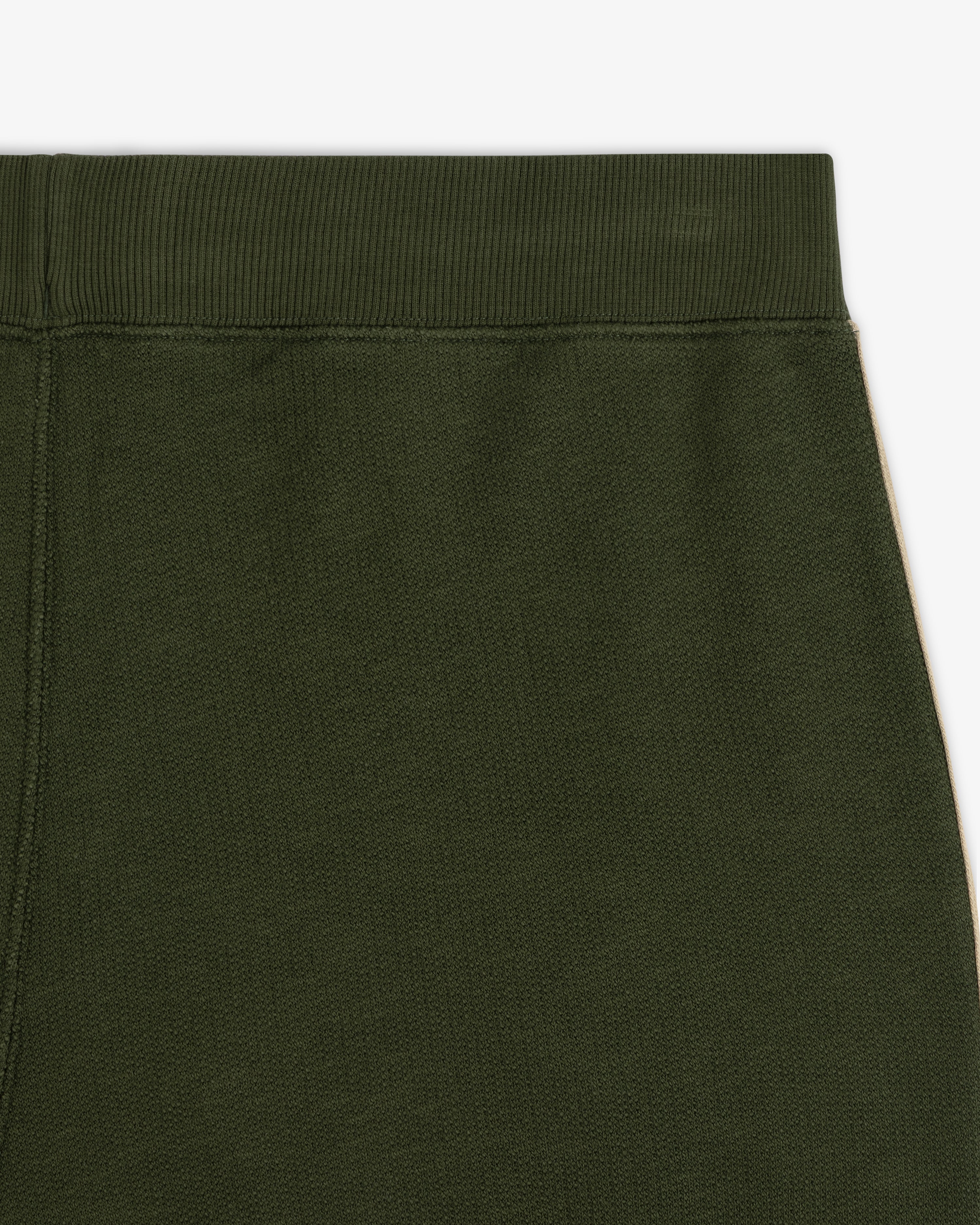 Close-up of the waistband and upper section of Saint George Track Pant in olive green against a white background.