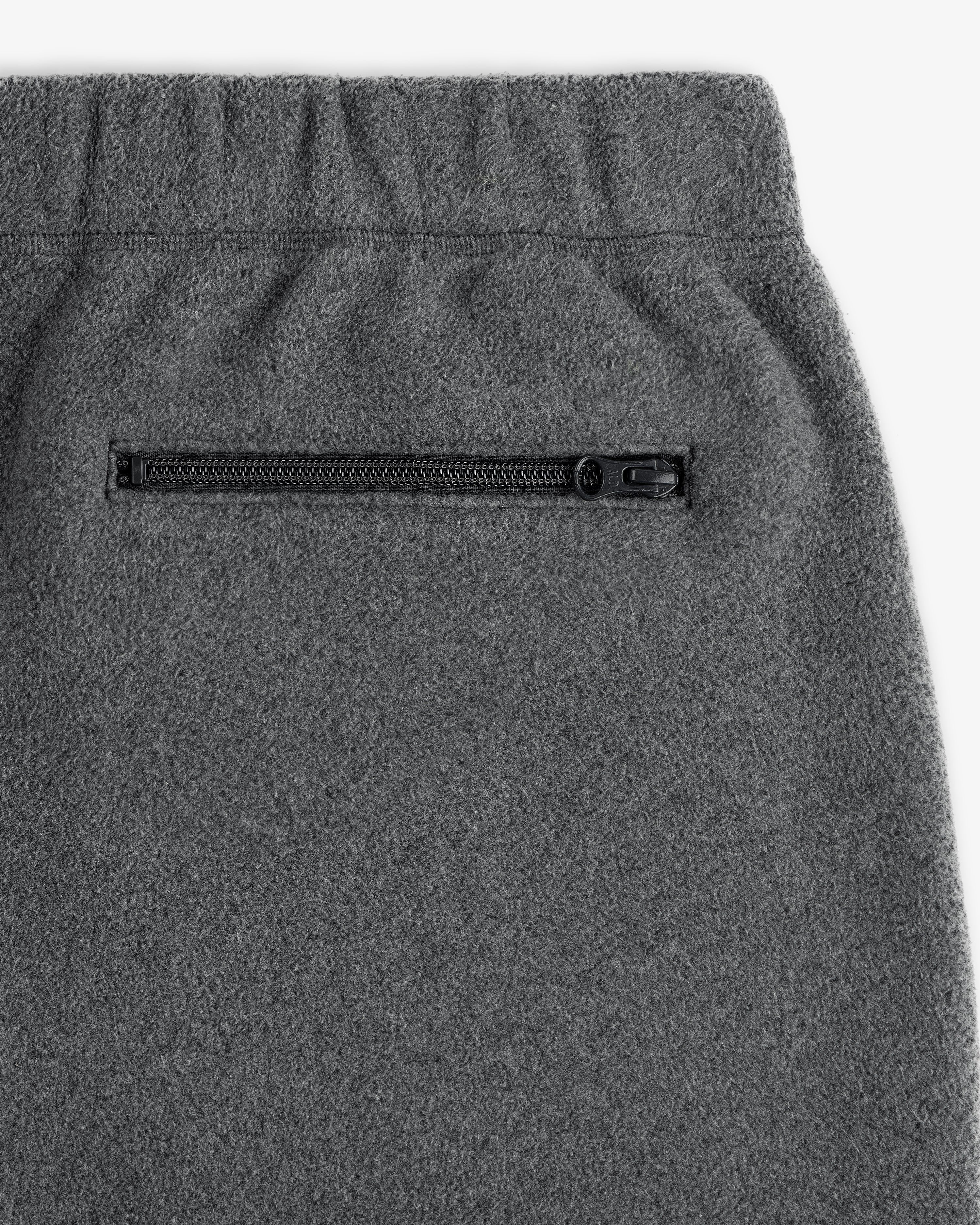 Close-up of Crest Fleece Sweatpant in gray with elastic waistband and side zippered pocket.
